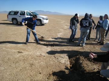 Digging a trench to determine the soil layers within the crack.