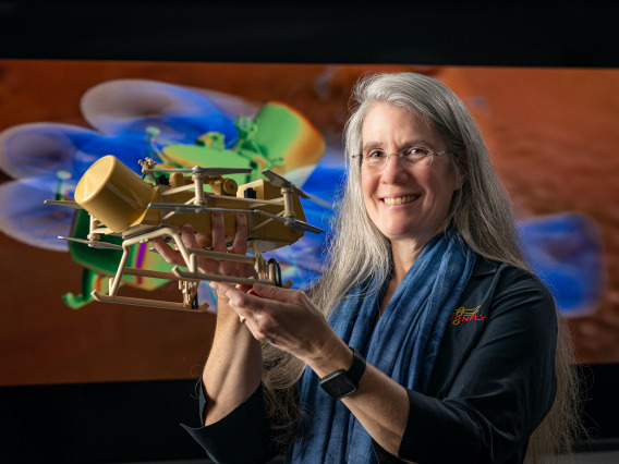 Elizabeth Turtle holding model of Dragonfly spacecraft.