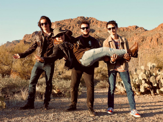 Photo of the four members of Daytrails in an iconic desert landscape