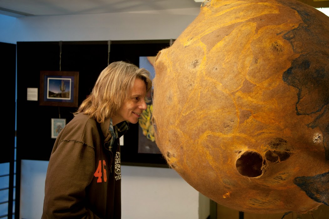 Prof. Caitlin Griffith looking at a sculpture.