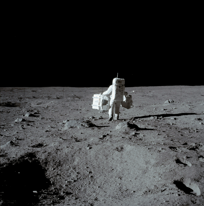 Moving gif of an Apollo astronaut walking toward the lunar horizon, with the Art of Planetary Science logo rising and sinking behind the horizon