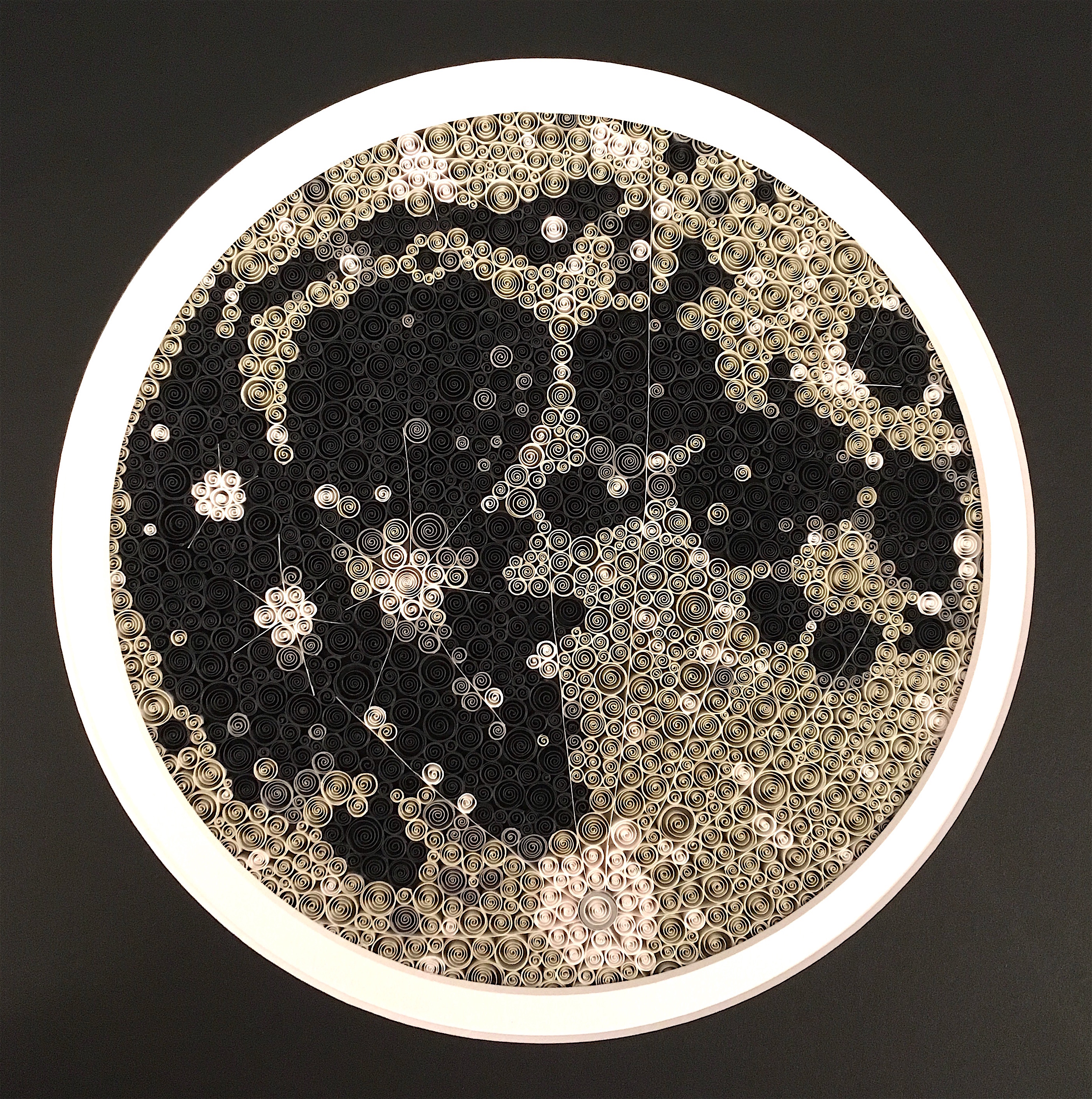 Paper quilled version of the full Moon composed of 2000 small coils of paper in shades of grey.