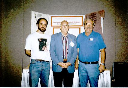 Clemmett, Gibson, and McKay posing in front of a poster