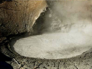 Mud Volcano, an acid spring which is vapor-dominated, that is, it doesn't discharge a lot of water. As such, mud builds up in the pool instead of being drained off. At Mud Volcano, the mud has been splashed around the pool and built up a spatter cone.