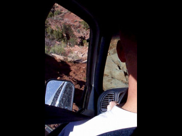 At first glance, this image may seem tame, but please notice that in front of Jason is the ground and in Jason's rearview mirror is the sky, so you have an idea of the attitude of the vehicles as we came down Elephant Hill.	