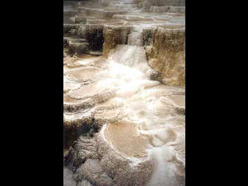 The white areas are old travertine deposits, and the orange part is where water currently flows.