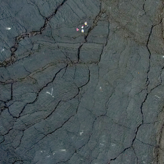 Extensive photogrammetric surveys were done using quadcopter UAVs of the lava flow surface, focusing on the margins and surrounding substrate that interacted with the lava flow. (Scientists for scale, upper image center.)