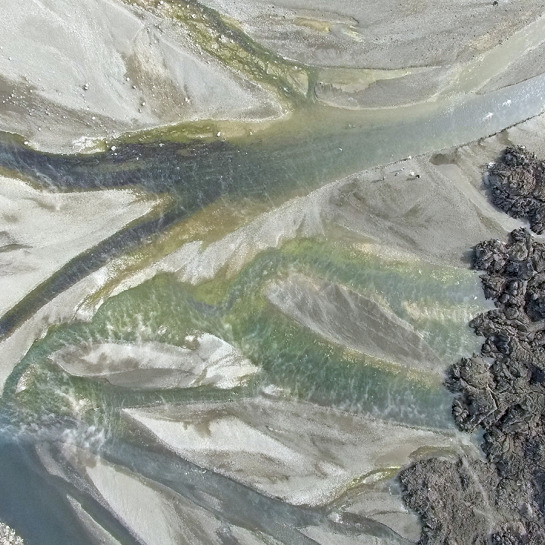 A UAV image showing a variety of algal populations (green) growing in the hot water emerging from the distal end of the lava flow.