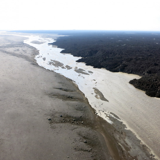 The aerial view from a kite and custom gimbal gives a wide-area perspective of the lava flow, river and erosional processes occurring at the margins. This river is upstream from hot springs that emerge from below the lava flow at its distal end and is likely hydrologically connected.