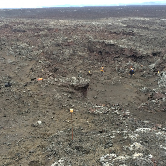The team is scouting out lava channels near the source vent and establishing a ground control network for subsequent UAV and LiDAR surveys. 