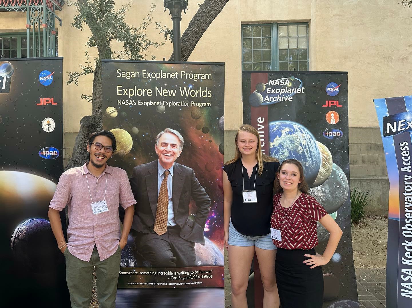 Students standing in front of Carl Sagan poster.