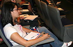 A student attends a lecture, clicker in hand.