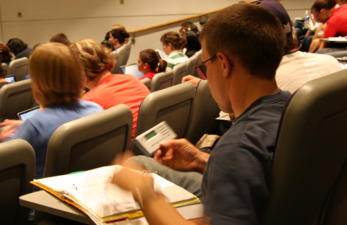 A student looks at his clicker during class.