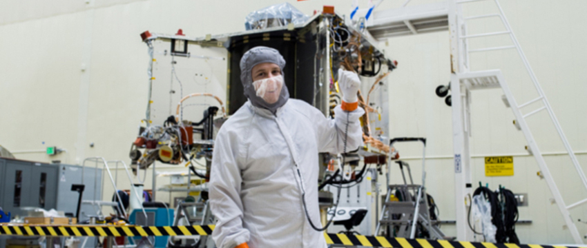 Systems engineer Bradley Williams with the OSIRIS-REx spacecraft in the Lockheed Martin cleanroom.