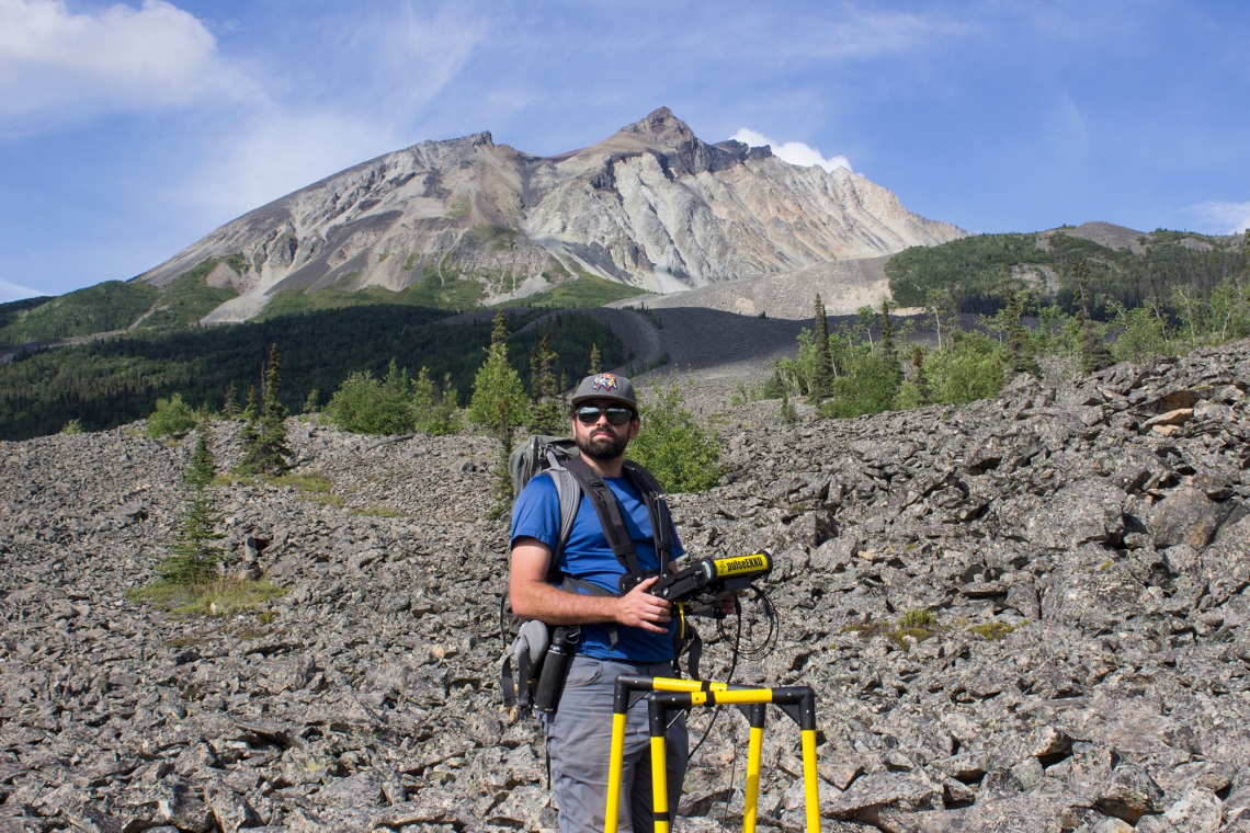 Lead author and graduate student Tyler Meng standing with radar equipment on the Sourdough rock glacier in Alaska in August 2021.