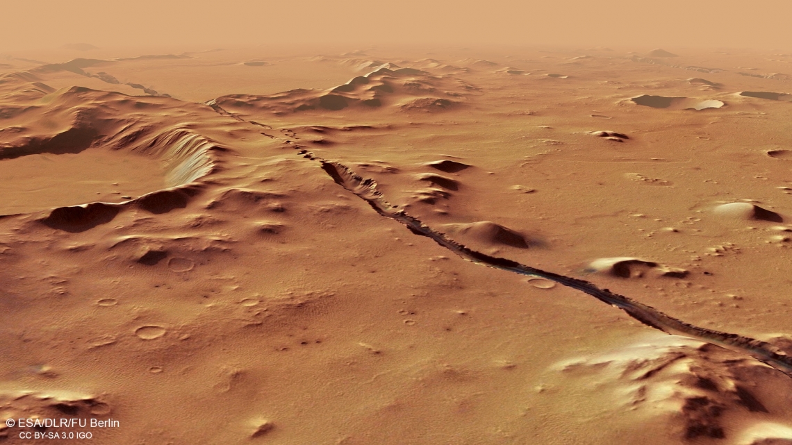 A view of the Cerberus Fossae system on Mars, showing fractures cutting through hills and craters.