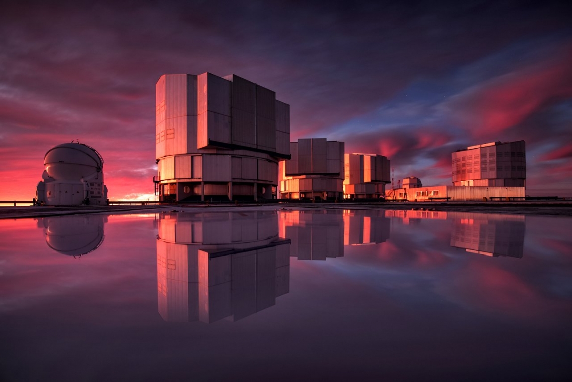 The Very Large Telescope, or VLT, at the Paranal Observatory in Chile's Atacama Desert. VLT's instrumentation was adapted to conduct a search for planets in the Alpha Centauri system as part of the Breakthrough initiatives. This image of the VLT is painted with the colors of the sunset reflected in water on the platform. A. Ghizzi Panizza/ESO