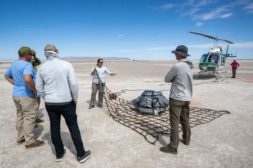 OSIRIS-REx team members practice getting a mock sample capsule packed for its helicopter flight