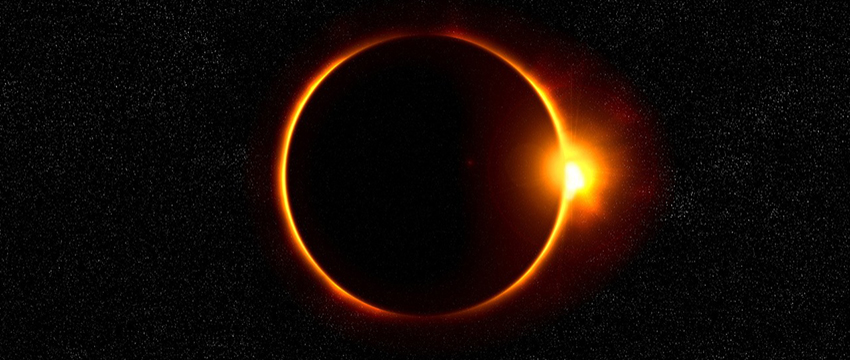 The sun is eclipsed by the moon against a starry background.