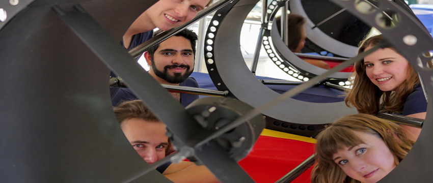 Undergraduate students Ryan Bronson, Sameep Arora, Damon Marco Colpo, Lindsie Jeffries, and Evelyn Hunten peer out from a telescope they built to track satellites.