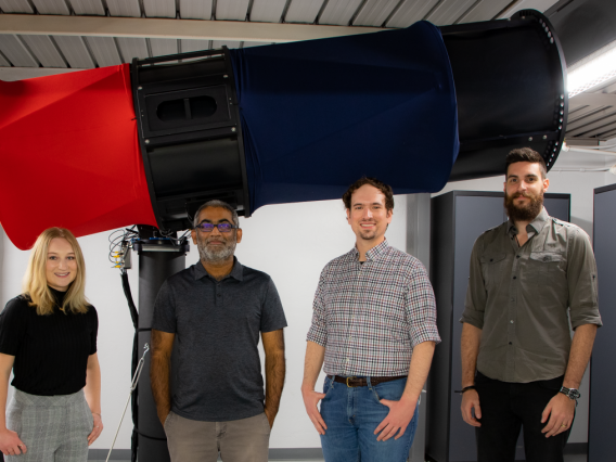 The UArizona Space Domain Awareness team - including Grace Halferty, Vishnu Reddy, Adam Battle and Tanner Campbell - stand in front of the RAPTORS-1 telescope on top of Kuiper Space Sciences Building. The team confirmed that the rocket booster slated to impact the Moon on March 4 is from the Chinese Chang'e 5-T1 mission and not from a SpaceX Falcon 9. Vishnu Reddy