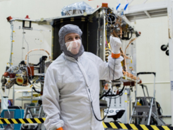 Systems engineer Bradley Williams with the OSIRIS-REx spacecraft in the Lockheed Martin cleanroom.