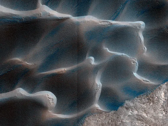The retreat of Mars' polar cap of frozen carbon dioxide during the spring and summer generates winds that drive the largest movements of sand dunes observed on the red planet. (Image: NASA/JPL/University of Arizona/USGS)