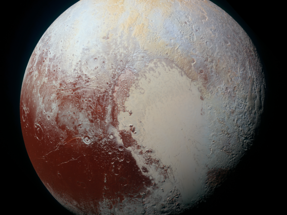 NASA image of Pluto in false color with a tan, vaguely heart-shaped region taking up the lower-right hand quadrant going into shadow; the left lobe of this region is smooth compared to other, more cratered regions which are shown in a brick red, icy white and yellow.